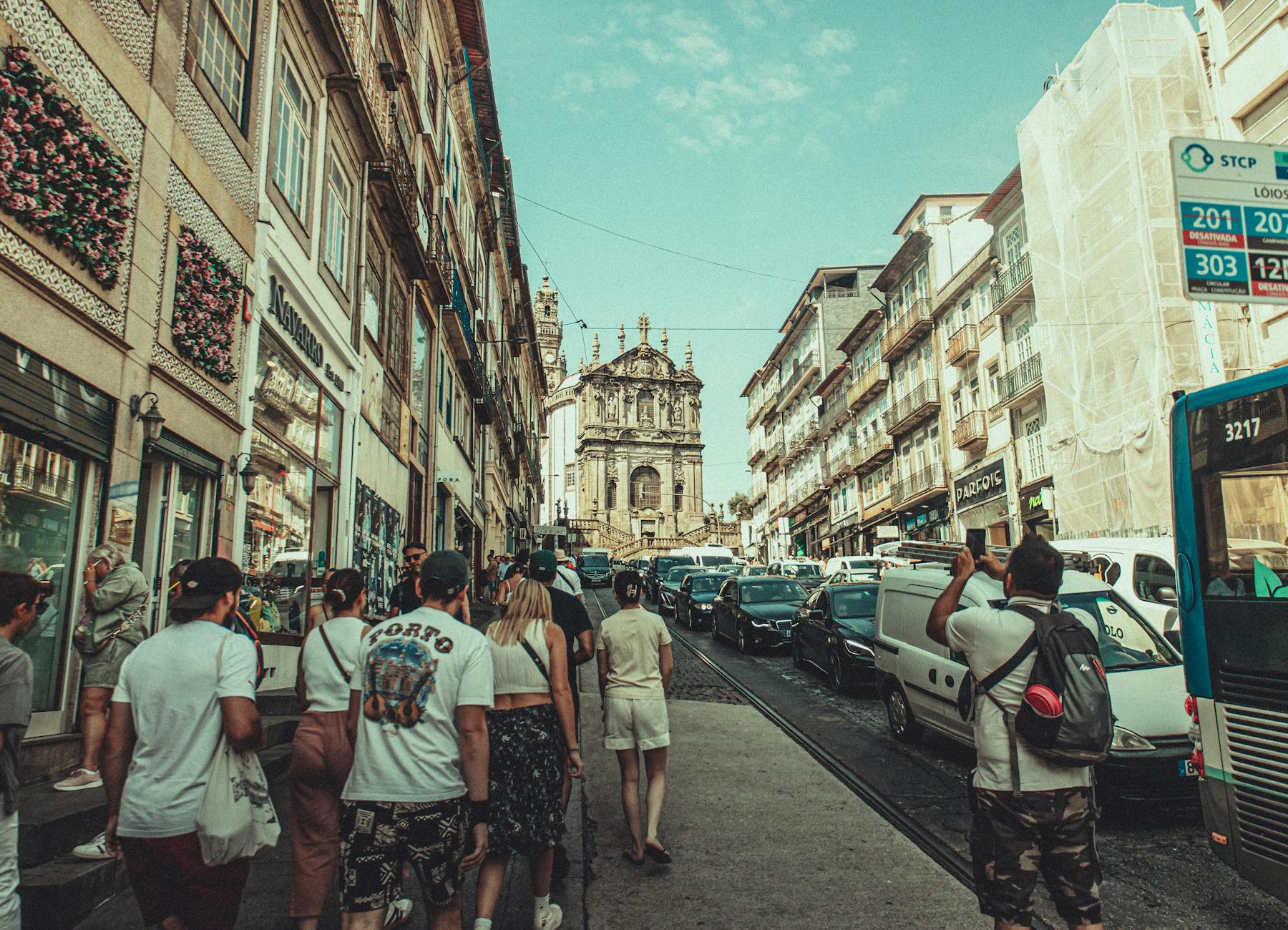 Tłoczna ulica w Porto z turystami i zabytkowymi kamienicami