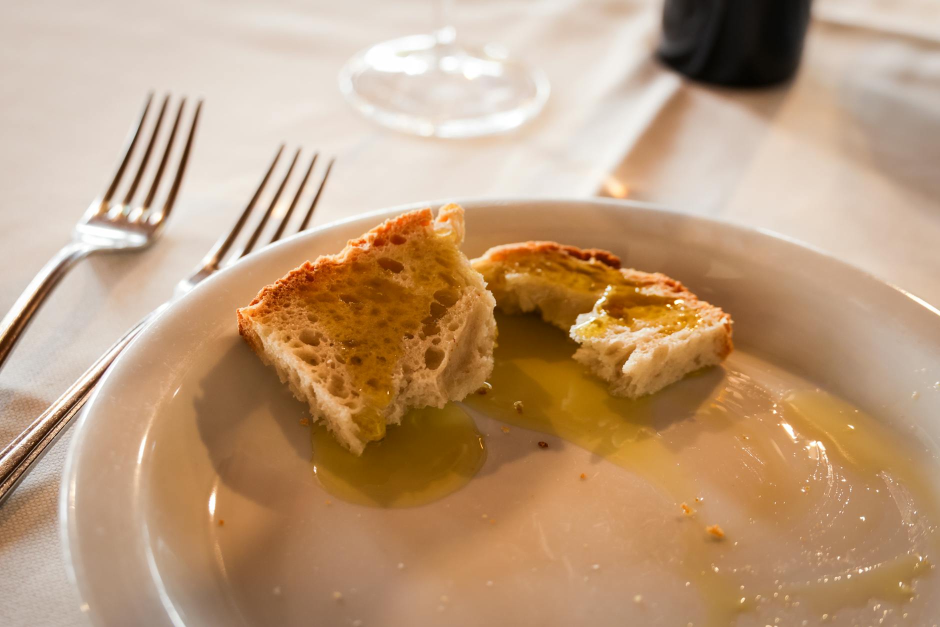 Kromki chleba z oliwą na białym talerzu w włoskiej restauracji