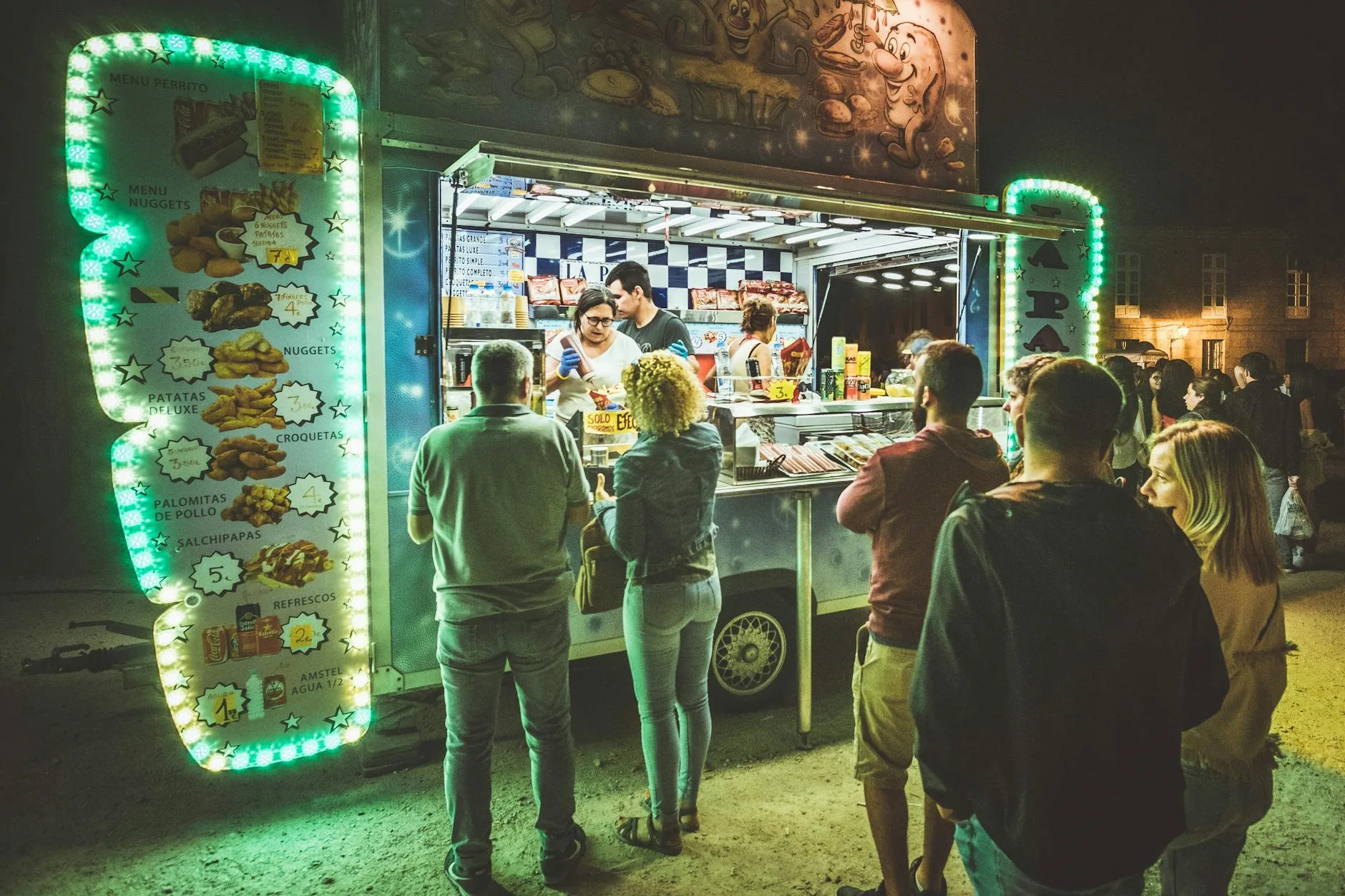 Ludzie jedzący nocne street food przy food trucku w tętniącym życiem mieście