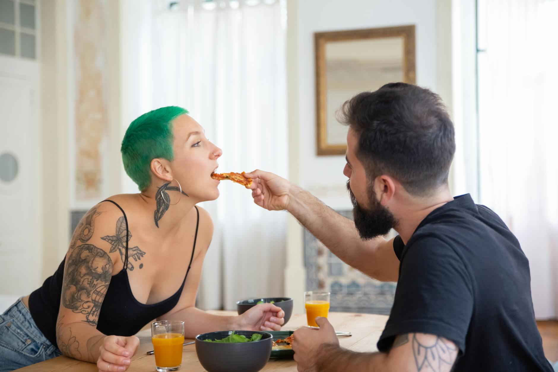 Para w przytulnym wnętrzu dzieli się kawałkiem pizzy