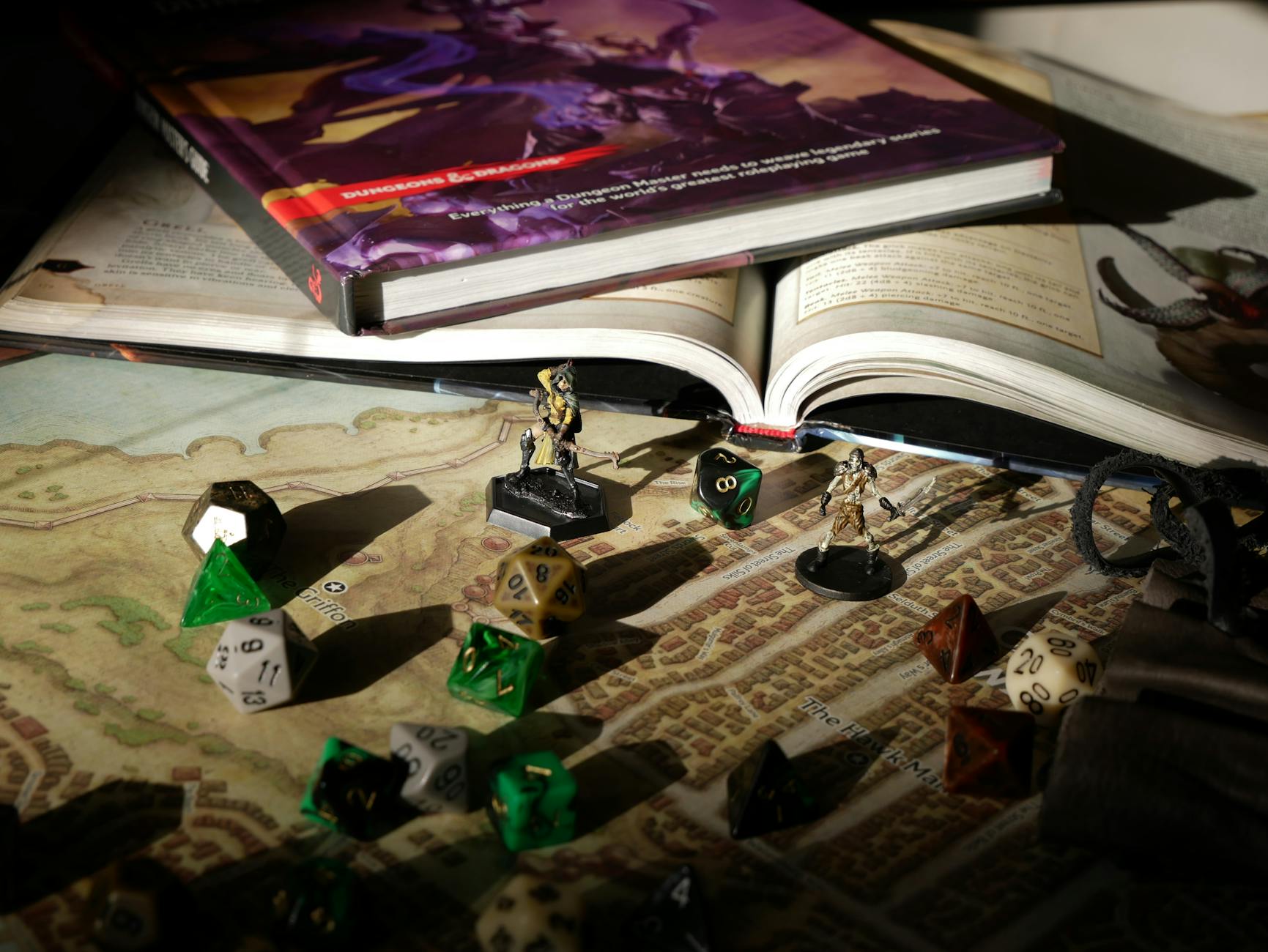 Zbliżenie na mapę RPG z podręcznikami, kostkami i figurkami