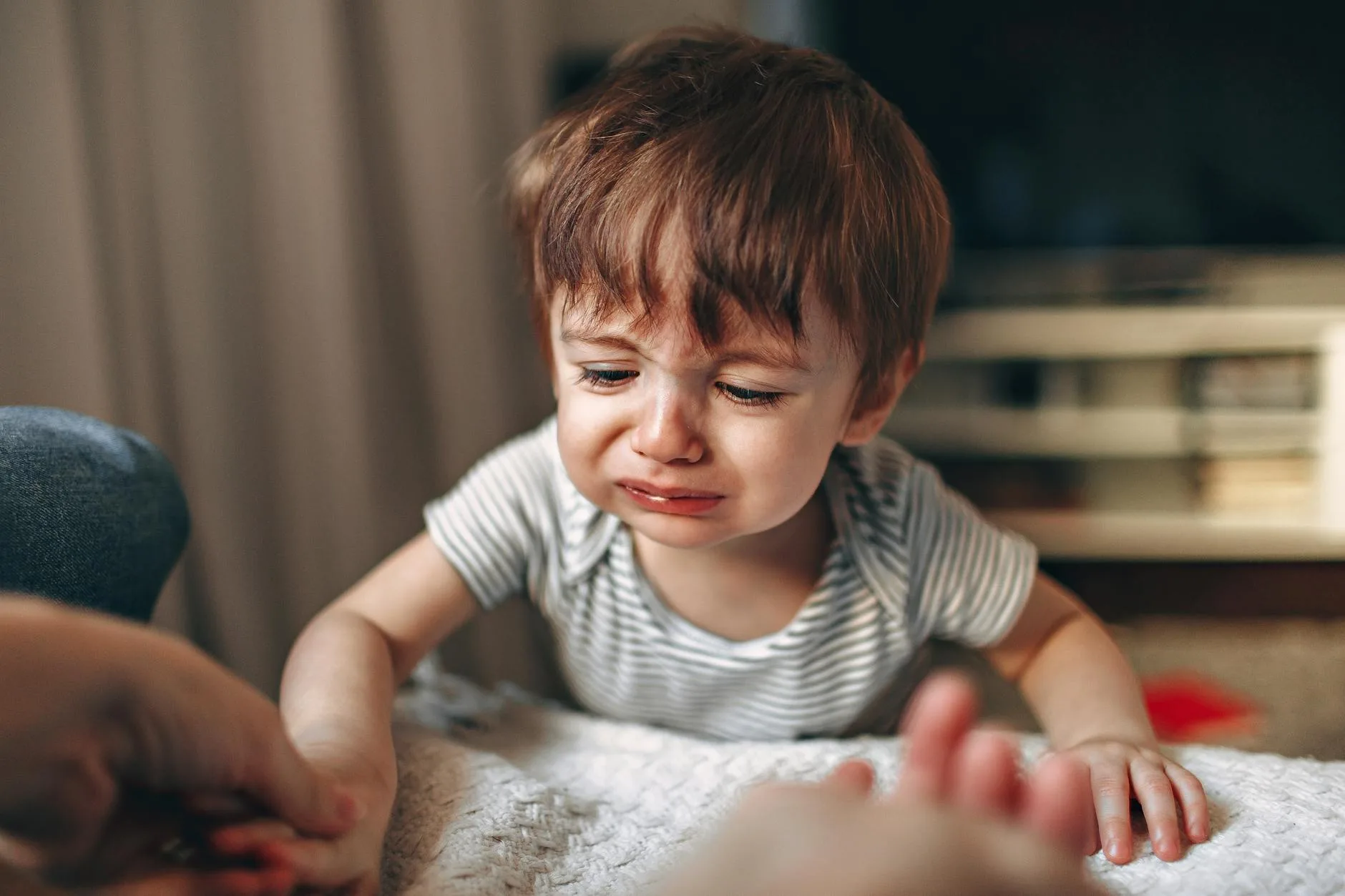 Zbliżenie zapłakanego dziecka w silnym emocjonalnym napięciu indoors