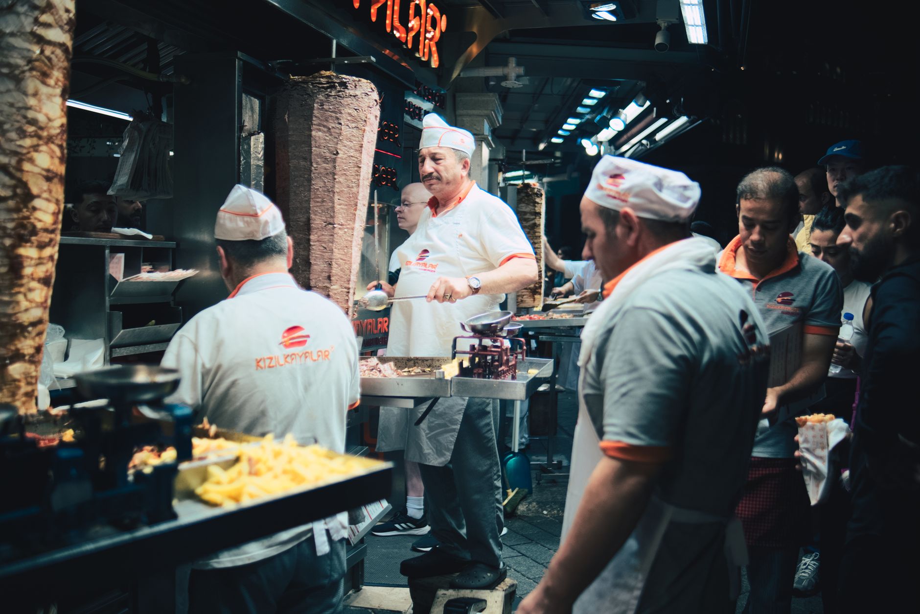 Kucharze przy ulicznej budce przygotowują kebab z poziomego rożna